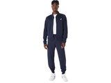hombre usando chaqueta asics court warm up jacket midnight durante calentamiento en cancha tenis