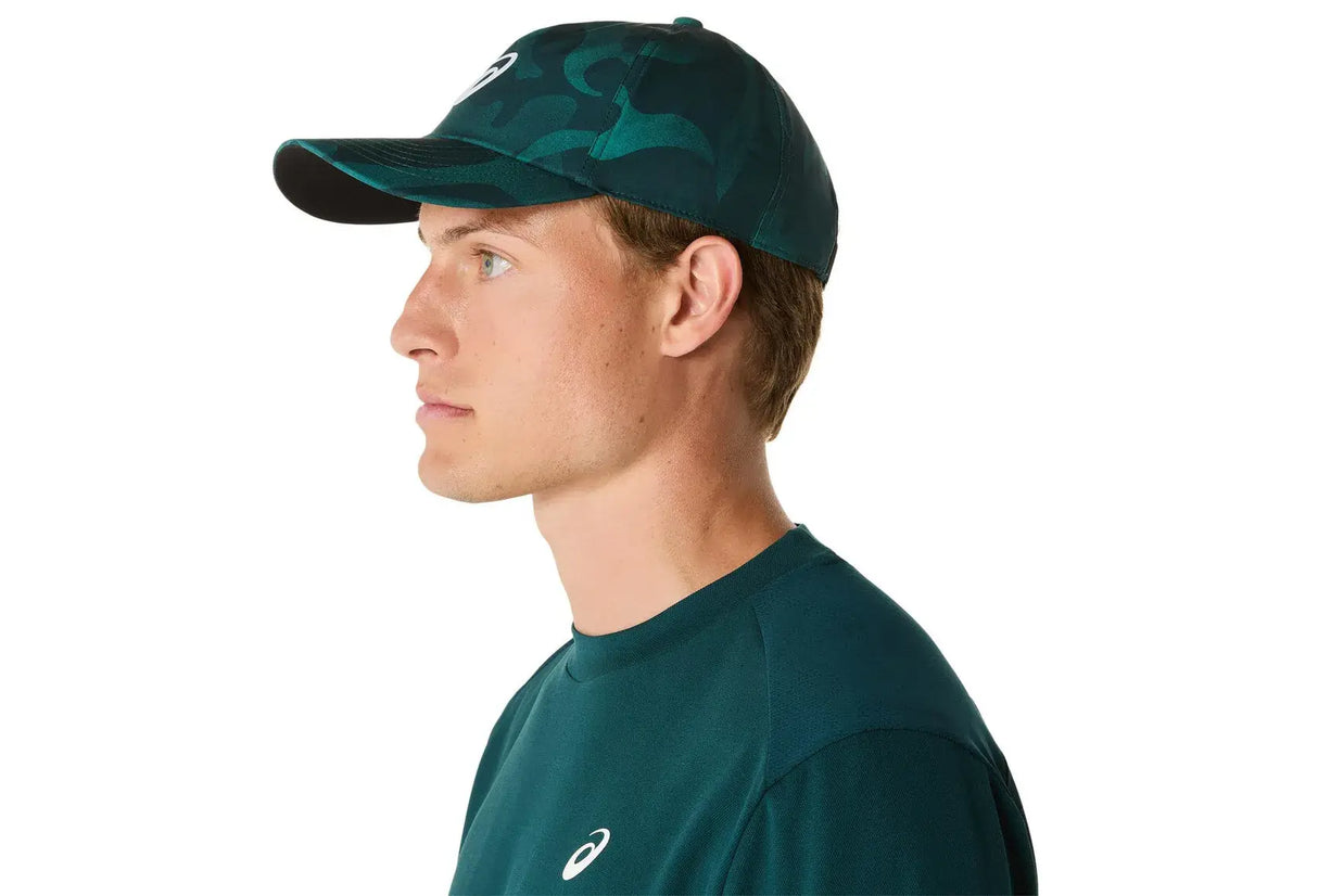 gorra deportiva asics verde oscuro con diseño estilizado y técnico